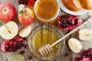 Rosh Hashana, Jewish New Year Holiday, Honey, apple, pomegranate, hala on a wooden table